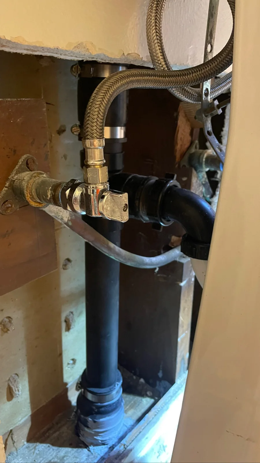 AWC project photo showing completed exposed sink drain and water-line connections before wall closure